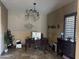 A home office with a modern chandelier, desk, and dark wood accents at 12937 W Calle De Sol --, Peoria, AZ 85383