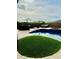 Backyard pool with artificial turf, built-in spa, and full poolside kitchen with seating area at 12937 W Calle De Sol --, Peoria, AZ 85383