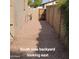 Gravel backyard with a block wall fence and wooden gate at 1308 S Spur --, Mesa, AZ 85204