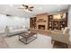 Comfortable living room featuring a cozy fireplace, built-in bookshelves, and a ceiling fan at 1308 S Spur --, Mesa, AZ 85204