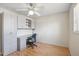 This office space boasts a desk with drawers, overhead storage, a rolling chair, and wood floors at 1308 S Spur --, Mesa, AZ 85204