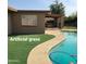 Backyard view of the pool and artificial grass with an open patio in the background at 1308 S Spur --, Mesa, AZ 85204