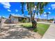 Single-story home with an expansive front yard and mature shade tree at 1444 W Wickieup Ln, Phoenix, AZ 85027