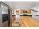 Full kitchen view with stainless steel refrigerator, wooden cabinets and island, plus tile flooring at 1444 W Wickieup Ln, Phoenix, AZ 85027