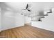 Open living space with light wood floors, a modern ceiling fan, and seamless flow to kitchen at 1444 W Wickieup Ln, Phoenix, AZ 85027