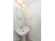 This half bath has a pedestal sink and an oval mirror with decorative lighting at 15818 N 25Th St # 124, Phoenix, AZ 85032