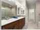 Bathroom featuring double sinks, stylish mirrors, and tiled walls at 16953 W Merrell St, Goodyear, AZ 85395