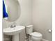 Half bathroom with modern oval mirror and pedestal sink at 16953 W Merrell St, Goodyear, AZ 85395