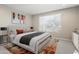 Stylishly staged bedroom featuring a plush bed, modern art, and a large window at 16953 W Merrell St, Goodyear, AZ 85395