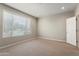 Carpeted bedroom with a window and a white door at 16953 W Merrell St, Goodyear, AZ 85395