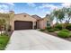 Charming single-story home with desert landscaping, a well-maintained lawn, and a three car garage at 16953 W Merrell St, Goodyear, AZ 85395