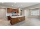 Spacious kitchen with wood cabinets, tile backsplash, stainless appliances, and a center island at 16953 W Merrell St, Goodyear, AZ 85395