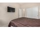 Comfortable bedroom with plush carpet, a large bed, a flatscreen TV, and closet space at 17773 W Manso St, Goodyear, AZ 85338