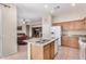 Open kitchen featuring granite countertops, an island with sink, and seamless flow to the living area at 17773 W Manso St, Goodyear, AZ 85338
