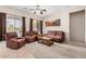Comfortable living room with plush brown seating, a wooden coffee table, and natural light from the windows at 17773 W Manso St, Goodyear, AZ 85338