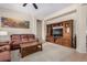 Spacious living room featuring a cozy brown sofa, wooden coffee table, and built-in entertainment center at 17773 W Manso St, Goodyear, AZ 85338