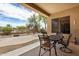 Cozy covered patio with string lights, dining table, and view of the desert landscaped backyard at 17773 W Manso St, Goodyear, AZ 85338