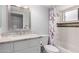 Bright bathroom with a single sink vanity, shower with a glass door, and floral shower curtain at 18002 N 12Th St # 45, Phoenix, AZ 85022