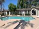 Community swimming pool surrounded by mature trees on a sunny day at 18002 N 12Th St # 45, Phoenix, AZ 85022