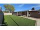 Home's backyard featuring an artificial lawn, covered patio, and swing at 1904 E Jarvis Ave, Mesa, AZ 85204