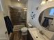 Modern bathroom with a glass enclosed shower, stylish vanity, round mirror, and natural lighting at 1904 E Jarvis Ave, Mesa, AZ 85204