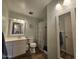 Well-lit bathroom featuring a vanity, toilet, shower with patterned curtain, and decorative mirror at 1904 E Jarvis Ave, Mesa, AZ 85204