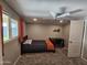 This carpeted bedroom features a single bed, ceiling fan, and a window with orange curtains at 1904 E Jarvis Ave, Mesa, AZ 85204