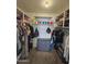 Organized walk-in closet with shelving and hanging rods for efficient storage solutions at 1904 E Jarvis Ave, Mesa, AZ 85204