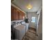 Functional laundry room with washer, dryer, and wooden cabinets for storage, plus an exit door at 1904 E Jarvis Ave, Mesa, AZ 85204