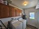 Functional laundry room with washer, dryer, and wooden cabinets for storage, plus an exit door at 1904 E Jarvis Ave, Mesa, AZ 85204