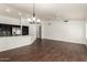 Open-concept living room with dark wood floors, white walls, and view of kitchen at 1917 E Lindrick Dr, Chandler, AZ 85249