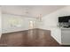Open-concept living room with dark wood floors, white walls, and shuttered windows at 1917 E Lindrick Dr, Chandler, AZ 85249