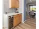 Stylish bar area with wine refrigerator, elegant countertops, and views of the dining room at 19550 N Grayhawk Dr # 2023, Scottsdale, AZ 85255