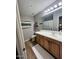 Well-lit bathroom features a wood vanity with white countertops and neutral walls at 19550 N Grayhawk Dr # 2023, Scottsdale, AZ 85255