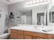 Bright bathroom featuring a wooden vanity with a large mirror, offering a clean and modern aesthetic at 19550 N Grayhawk Dr # 2023, Scottsdale, AZ 85255