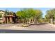The gated entrance to the community features stone pillars, desert plants, and mature trees at 19550 N Grayhawk Dr # 2023, Scottsdale, AZ 85255