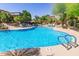 Resort-style community pool with palm trees, lounge chairs, and a shaded seating area at 19550 N Grayhawk Dr # 2023, Scottsdale, AZ 85255