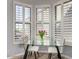 Bright breakfast nook featuring a glass table, seating for two, and lovely plantation shutters at 19550 N Grayhawk Dr # 2023, Scottsdale, AZ 85255