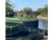 Beautiful golf course view with a green, pond, and wooden retaining wall, offering a serene backdrop at 19550 N Grayhawk Dr # 2023, Scottsdale, AZ 85255