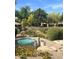 Community hot tub surrounded by lush landscaping and decorative rocks, offering a tranquil retreat at 19550 N Grayhawk Dr # 2023, Scottsdale, AZ 85255