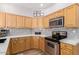 Modern kitchen featuring wooden cabinetry, stainless steel appliances, and tile backsplash at 19550 N Grayhawk Dr # 2023, Scottsdale, AZ 85255