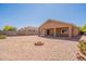Gravel backyard featuring a covered patio, privacy wall, desert landscaping, and a custom firepit at 1956 N Hubbard Ln, Casa Grande, AZ 85122