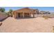 Spacious backyard featuring a covered patio, gravel landscaping, and block wall fencing at 1956 N Hubbard Ln, Casa Grande, AZ 85122