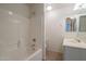 Bright, tiled bathroom with white fixtures, including a shower-tub combo and vanity sink at 1956 N Hubbard Ln, Casa Grande, AZ 85122