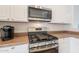 Close up of stainless steel microwave and gas burning stove with white cabinets at 1956 N Hubbard Ln, Casa Grande, AZ 85122