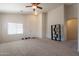 Spacious carpeted living room featuring a ceiling fan, neutral walls, and a welcoming entrance at 1956 N Hubbard Ln, Casa Grande, AZ 85122