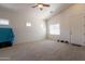 Bright, carpeted living room with a ceiling fan and natural light, perfect for relaxing or entertaining at 1956 N Hubbard Ln, Casa Grande, AZ 85122