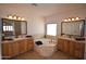 Primary bathroom with dual vanities, a soaking tub, and large mirrors, and neutral color palette at 19880 W Desert Views Dr, Casa Grande, AZ 85122