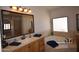 The bathroom has double vanities with ornate lighting and a corner tub with natural light at 19880 W Desert Views Dr, Casa Grande, AZ 85122