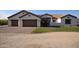 Charming single story home featuring a three car garage, manicured lawn and desert landscaping at 19880 W Desert Views Dr, Casa Grande, AZ 85122